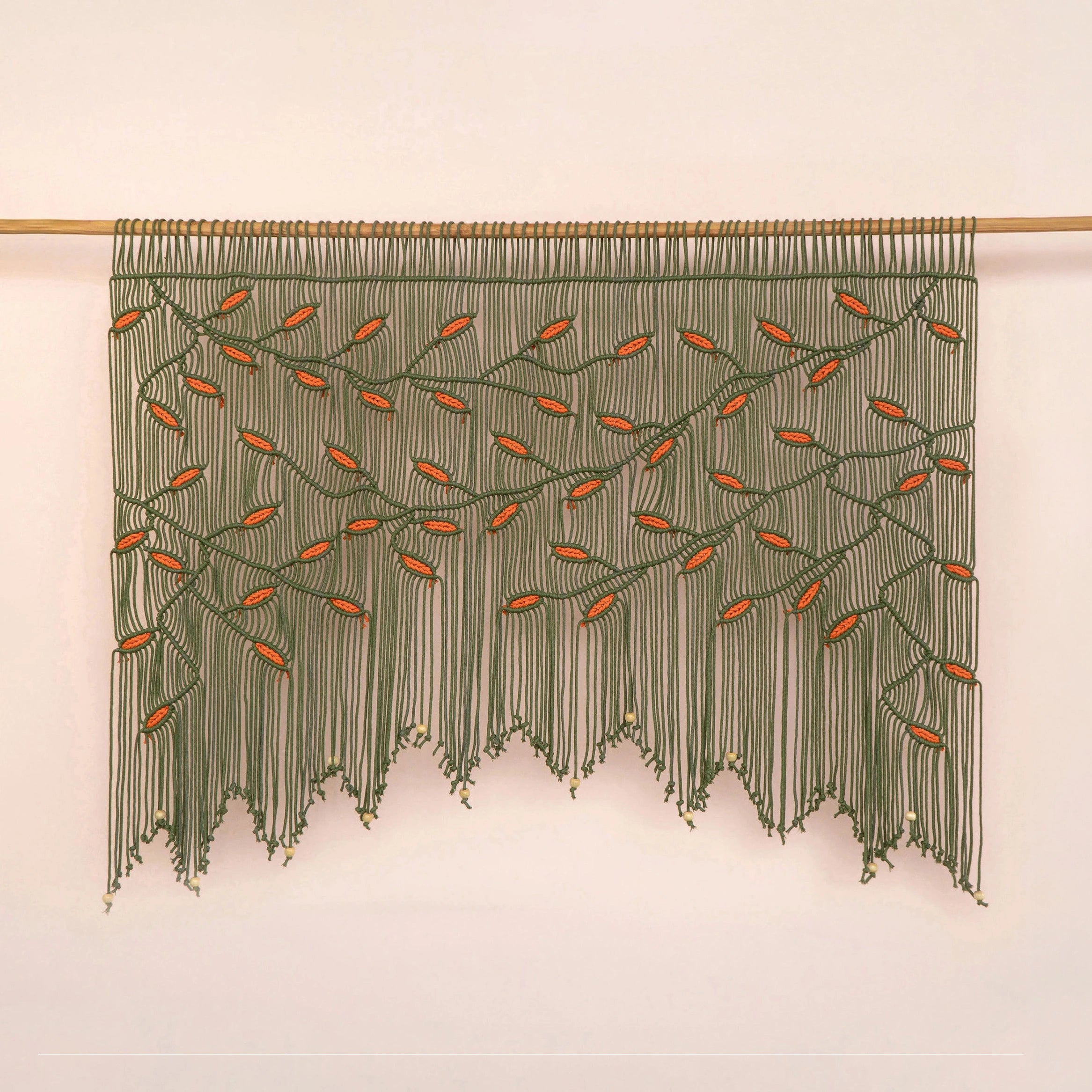 Handcrafted olive green macrame wall hanging featuring an intricate botanical canopy of deep green vines and vibrant orange leaves.